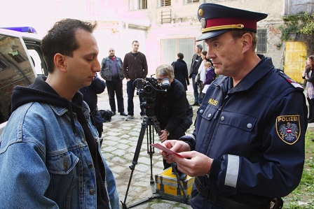 Foto von den Dreharbeiten zu "Die verrückte Welt der Ute Bock": Josef Hader spielt einen Polizisten, der gerade die Ausweise von Asylwerbern kontrolliert